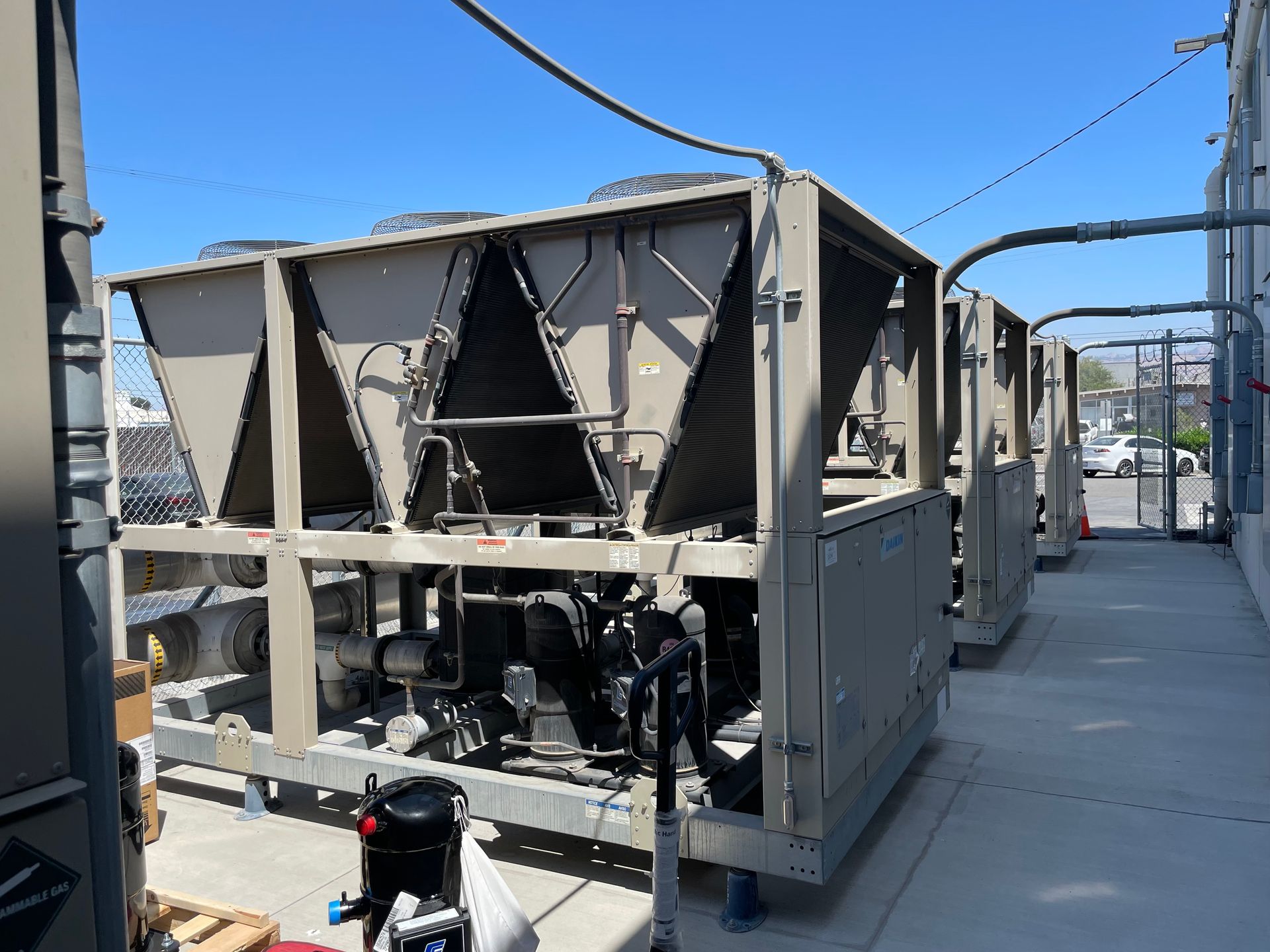A row of gray containers are sitting on the side of a building.