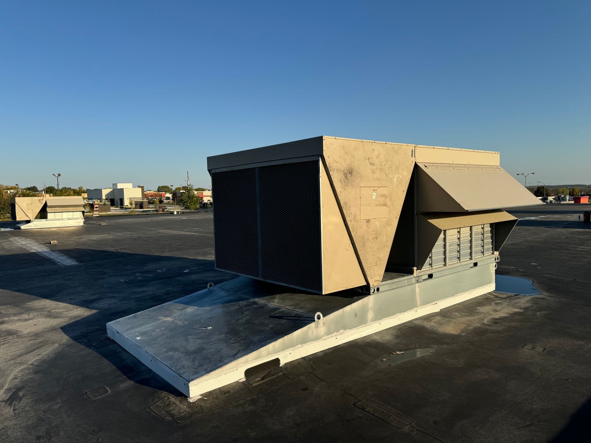 A large air conditioner is sitting on top of a roof.