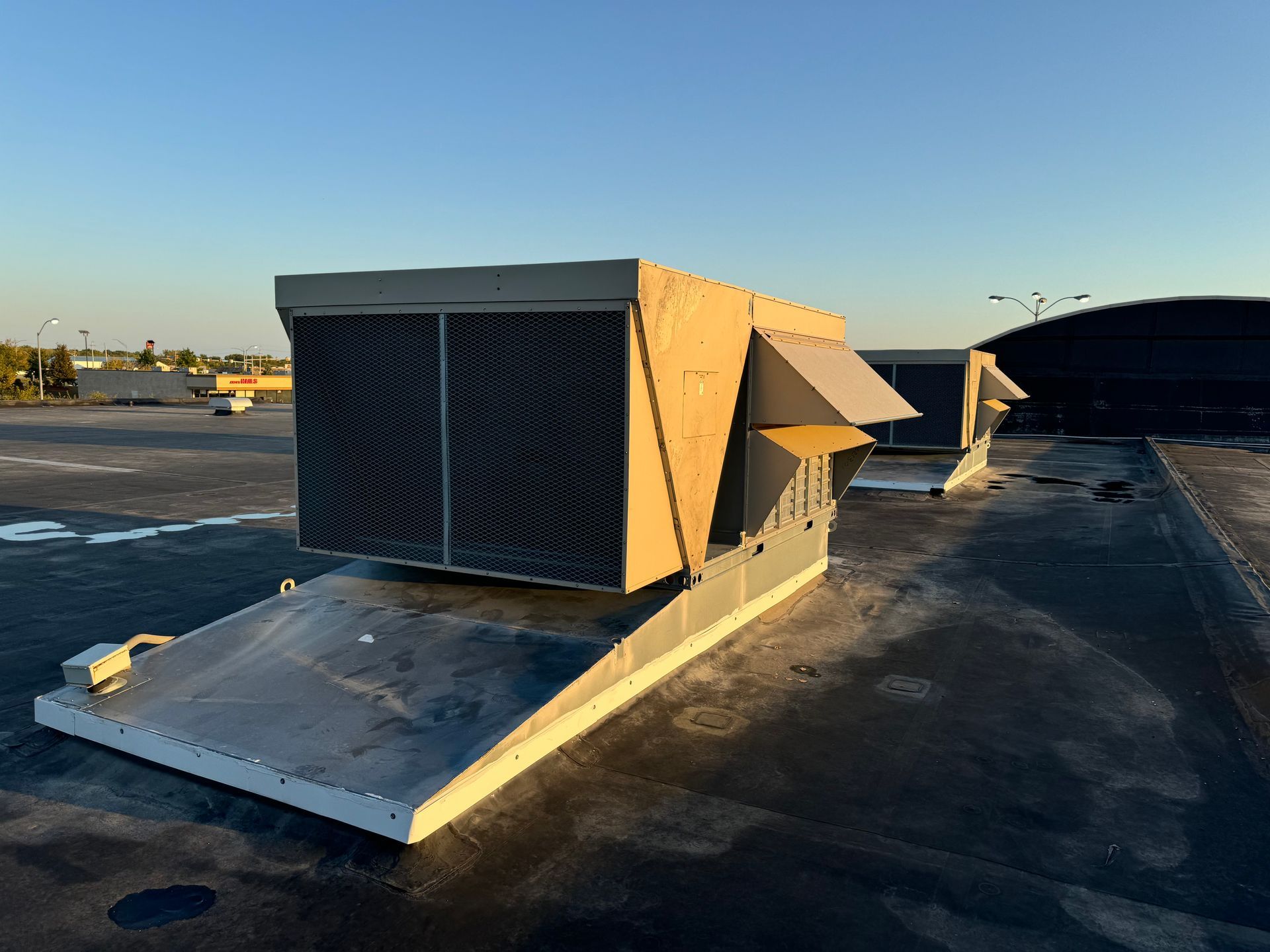 A large air conditioner is sitting on top of a roof.