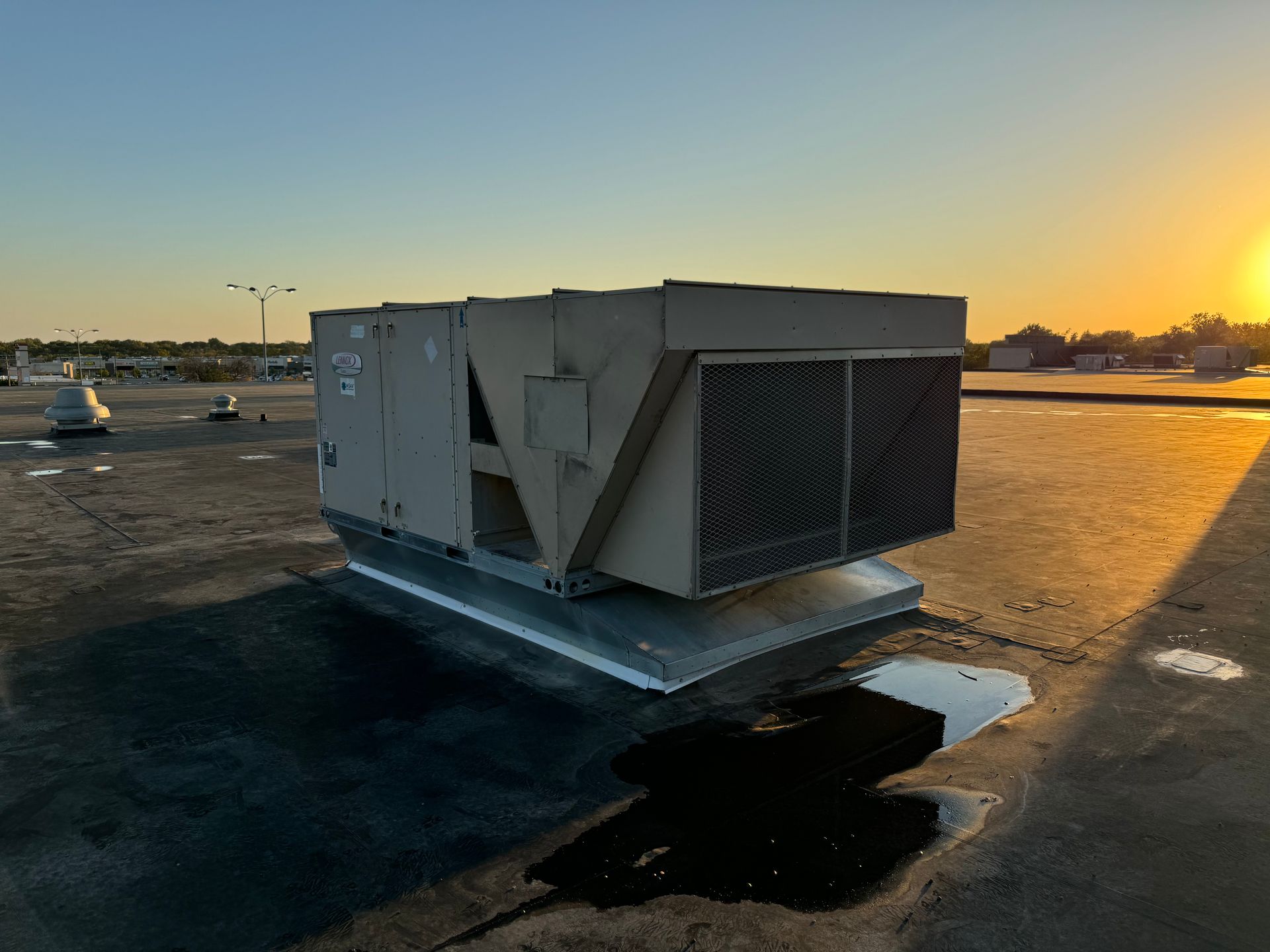 A large air conditioner is sitting on top of a roof.