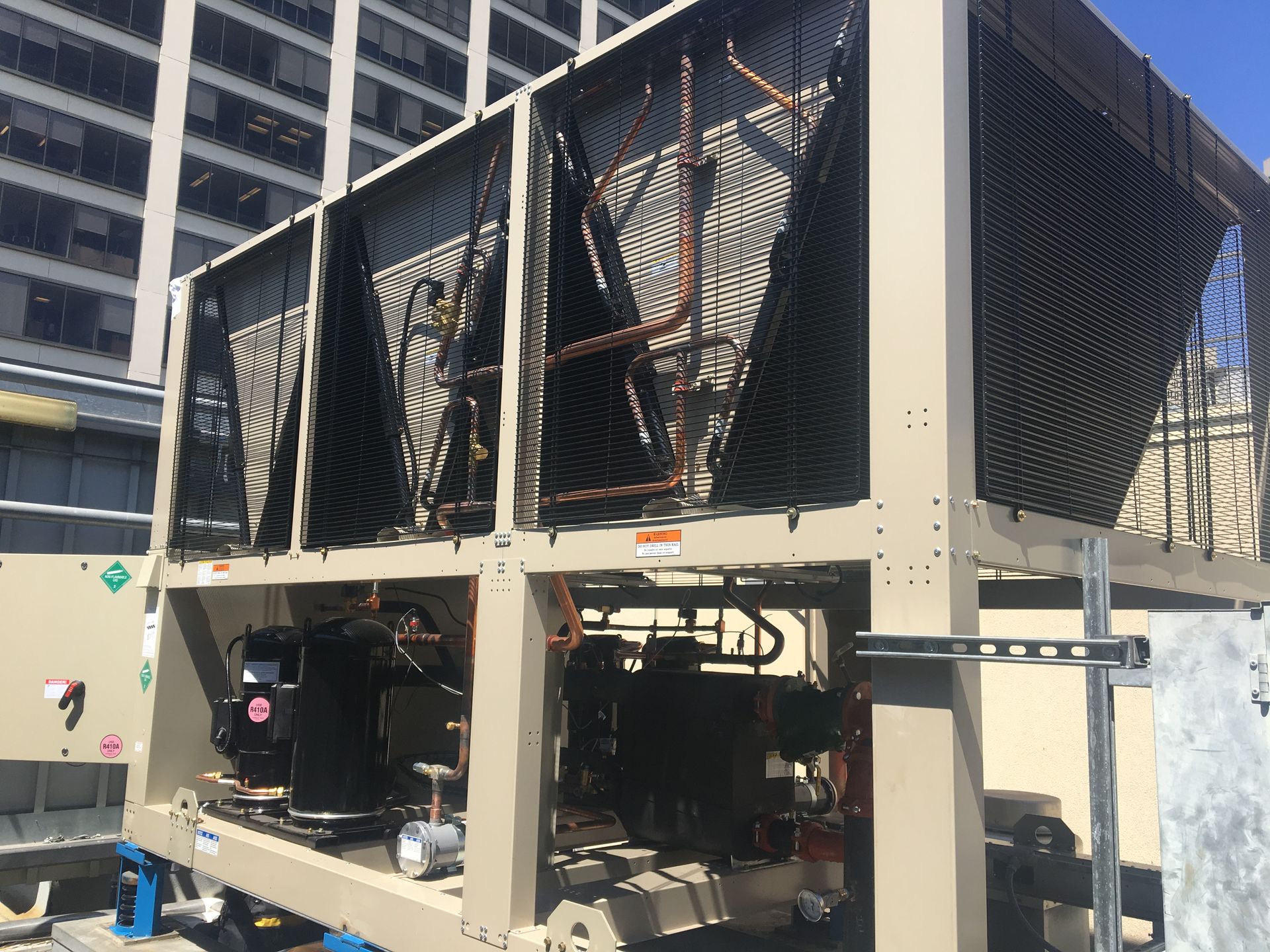 A large machine is sitting in front of a building.