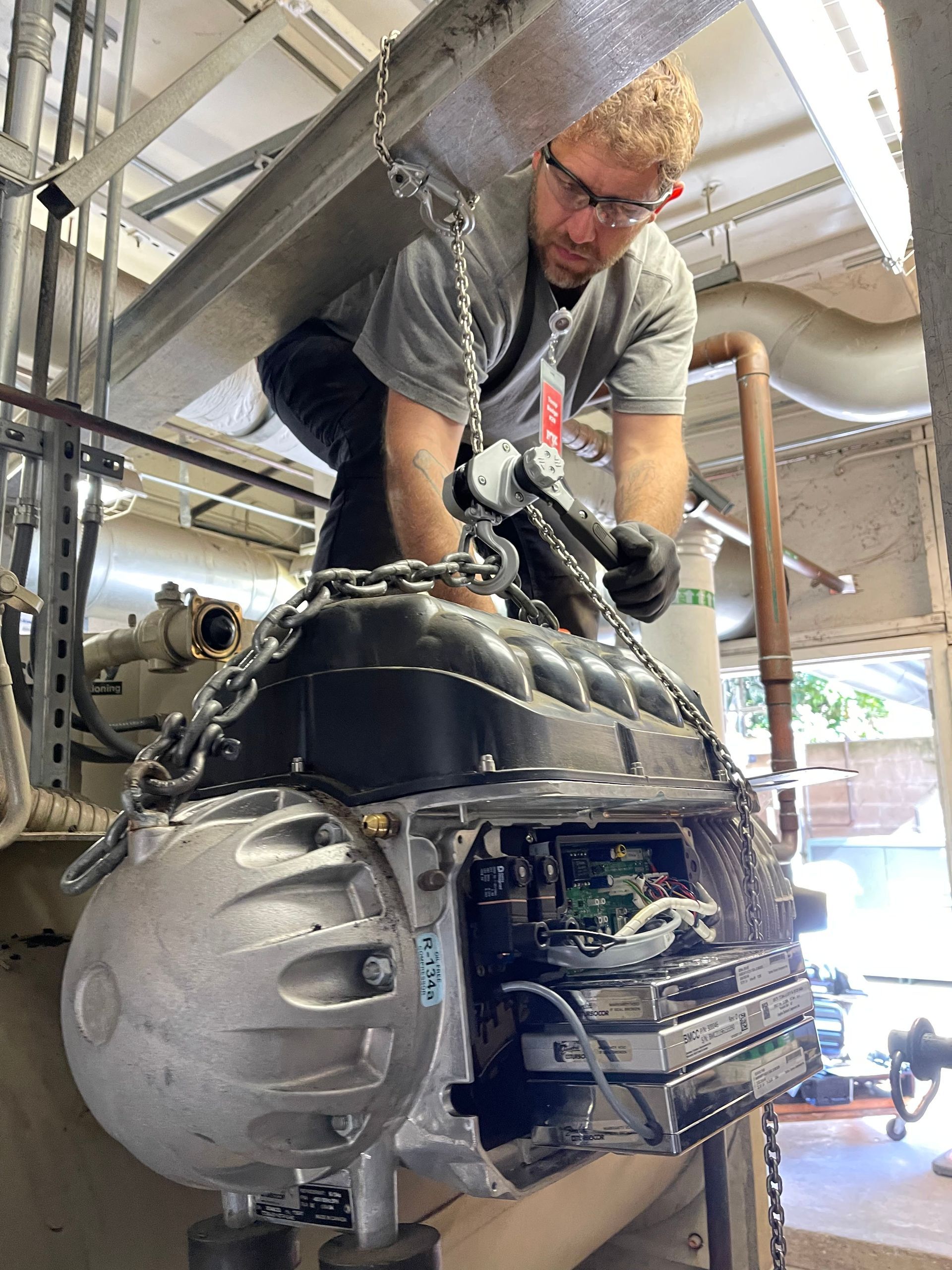 A man is working on a large engine in a factory.