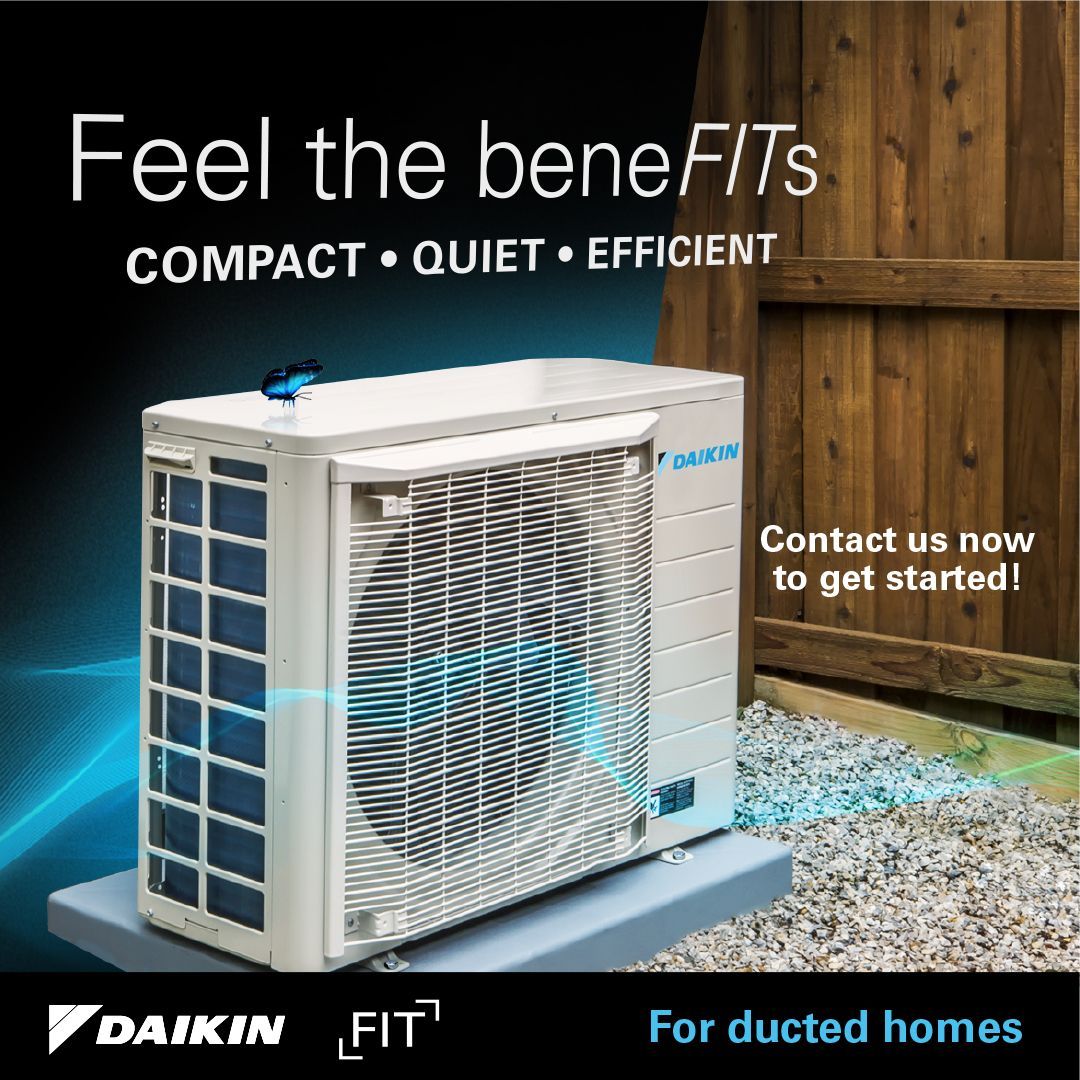 A daikin air conditioner is sitting on top of a concrete platform in front of a wooden fence.