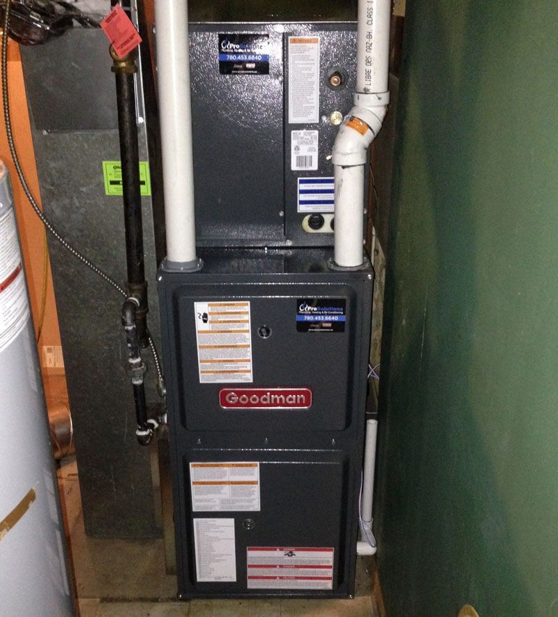 A goodman furnace is sitting in a corner of a room