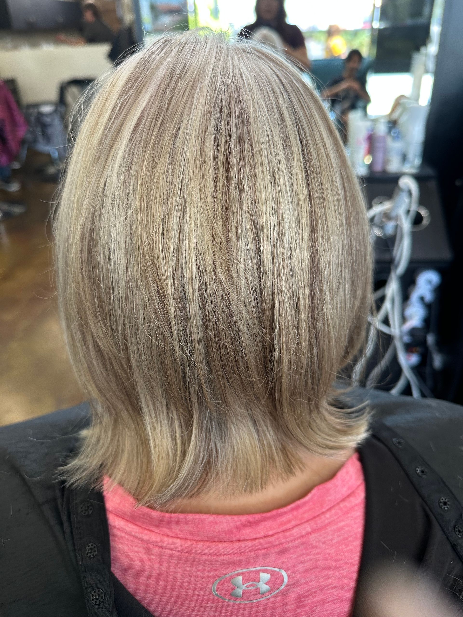 Woman with short, layered, blonde hair in a salon setting.