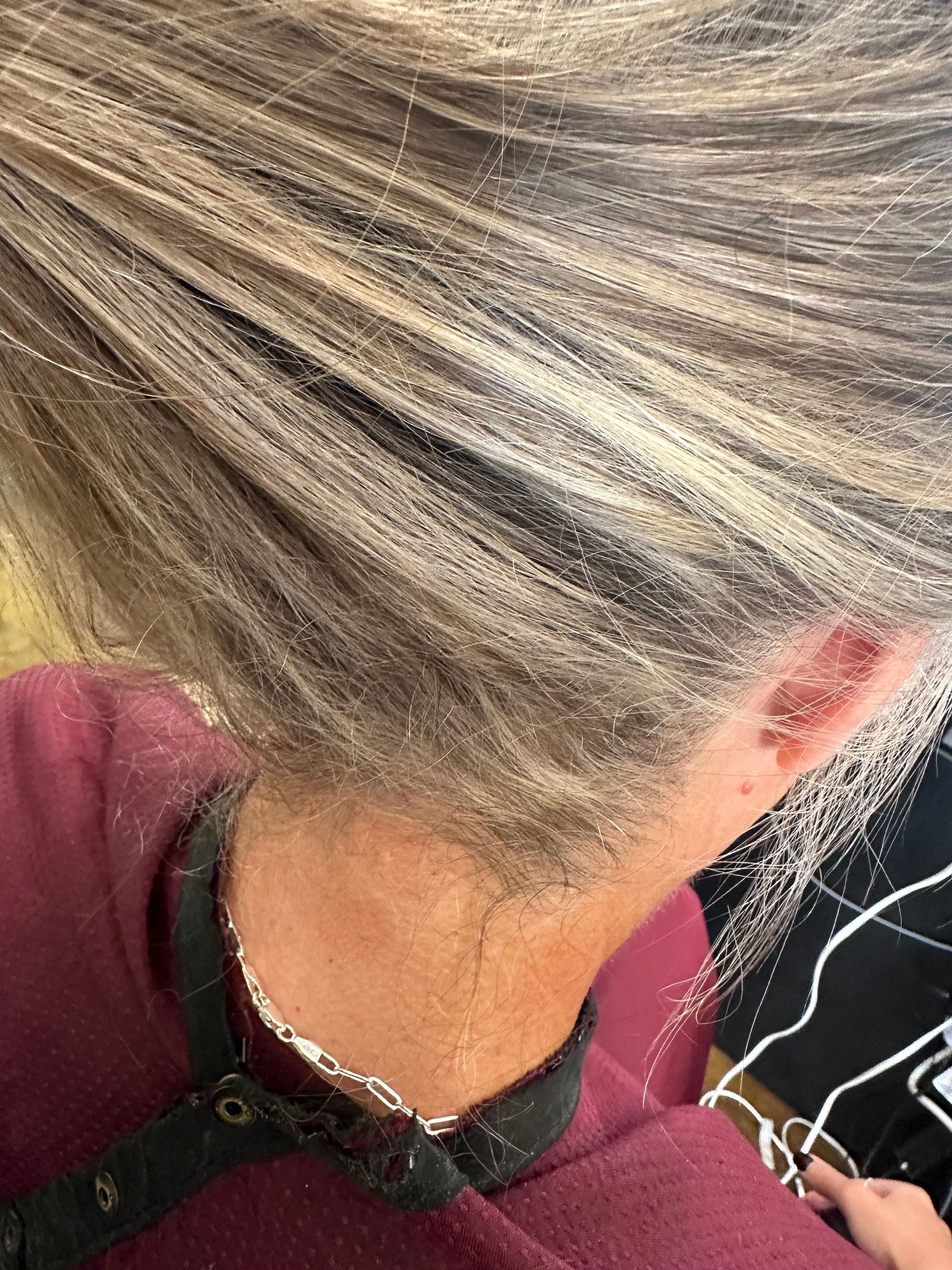 Person with blonde hair covered in a powdery substance; wearing a red shirt.