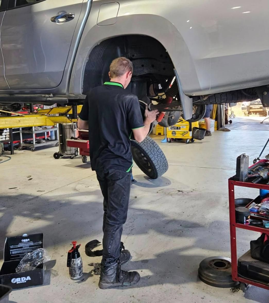A Man Is Working on A Truck in A Garage — Coalfields Mechanical & Towing in Blackwater, QLD
