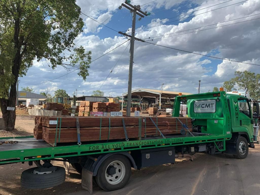 A Green Tow Truck Is Carrying a Load of Wood — Coalfields Mechanical & Towing in Blackwater, QLD