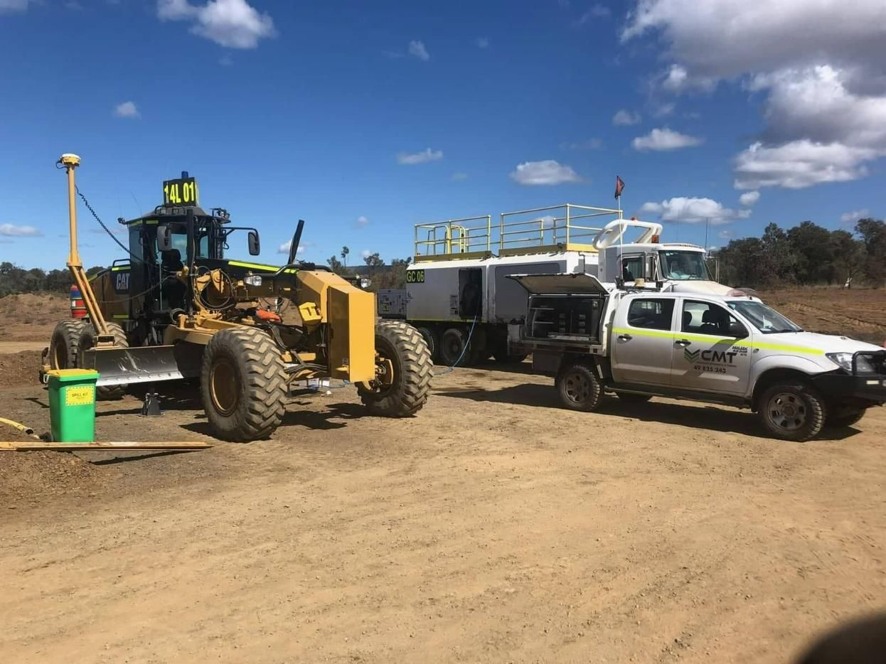 A Bulldozer Is Parked Next to A Truck in A Dirt Field — Coalfields Mechanical & Towing in Blackwater, QLD