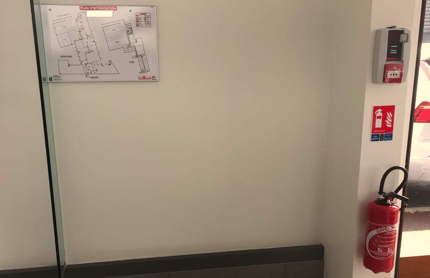 Un extincteur est accroché au mur à côté d'une carte.