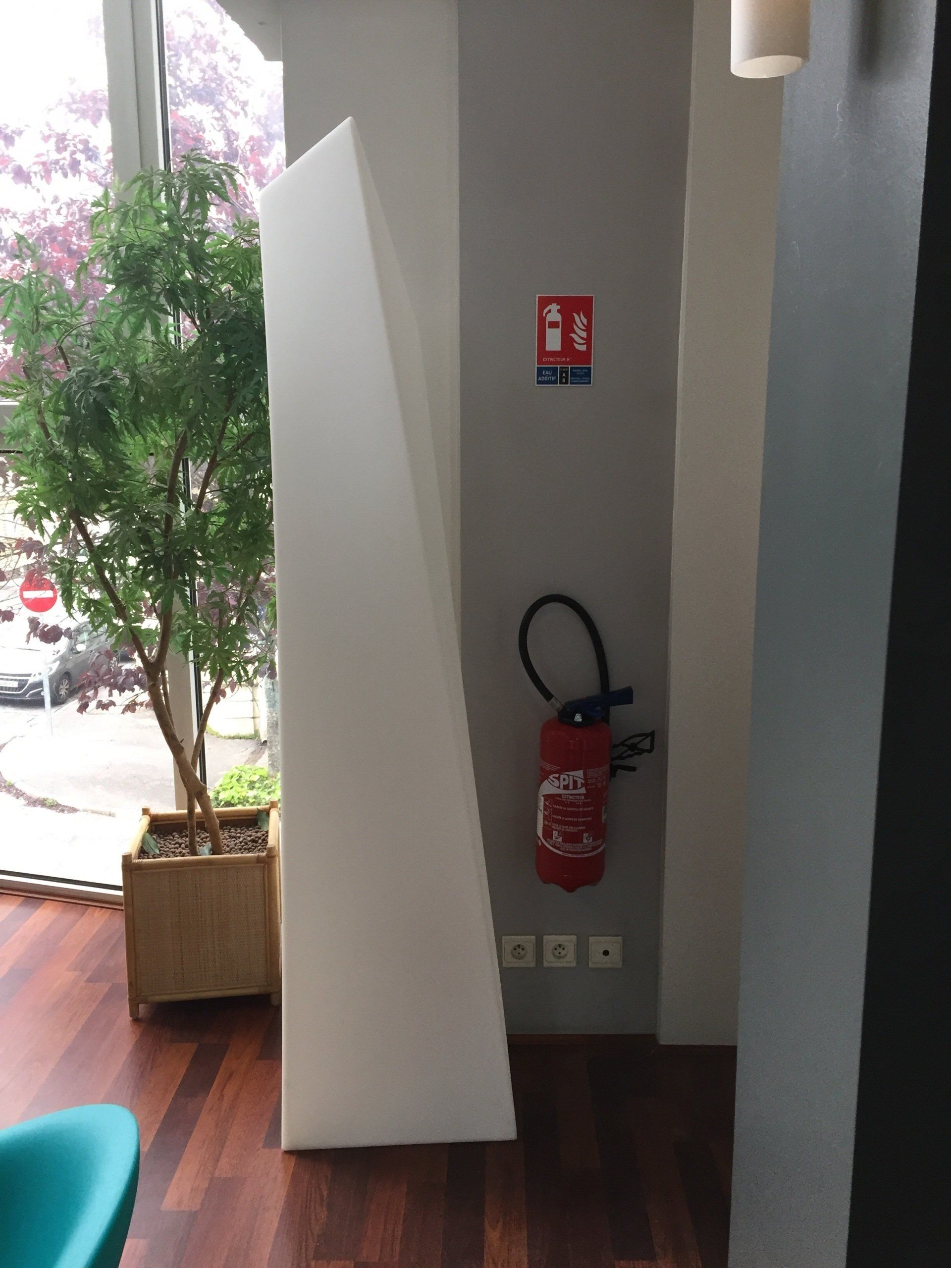 Un extincteur est accroché sur un mur à côté d'une fenêtre