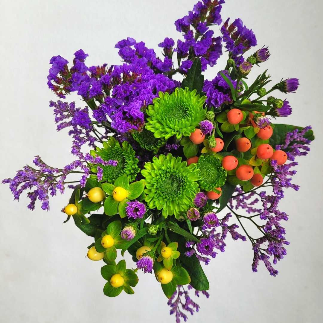 un ramo de flores de color púrpura y verde sobre un fondo blanco