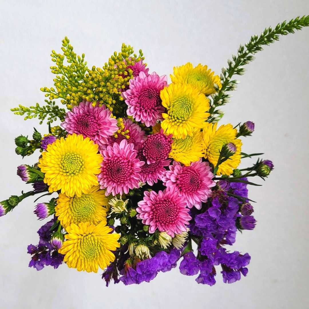 un ramo de flores de color púrpura y amarillo sobre un fondo blanco