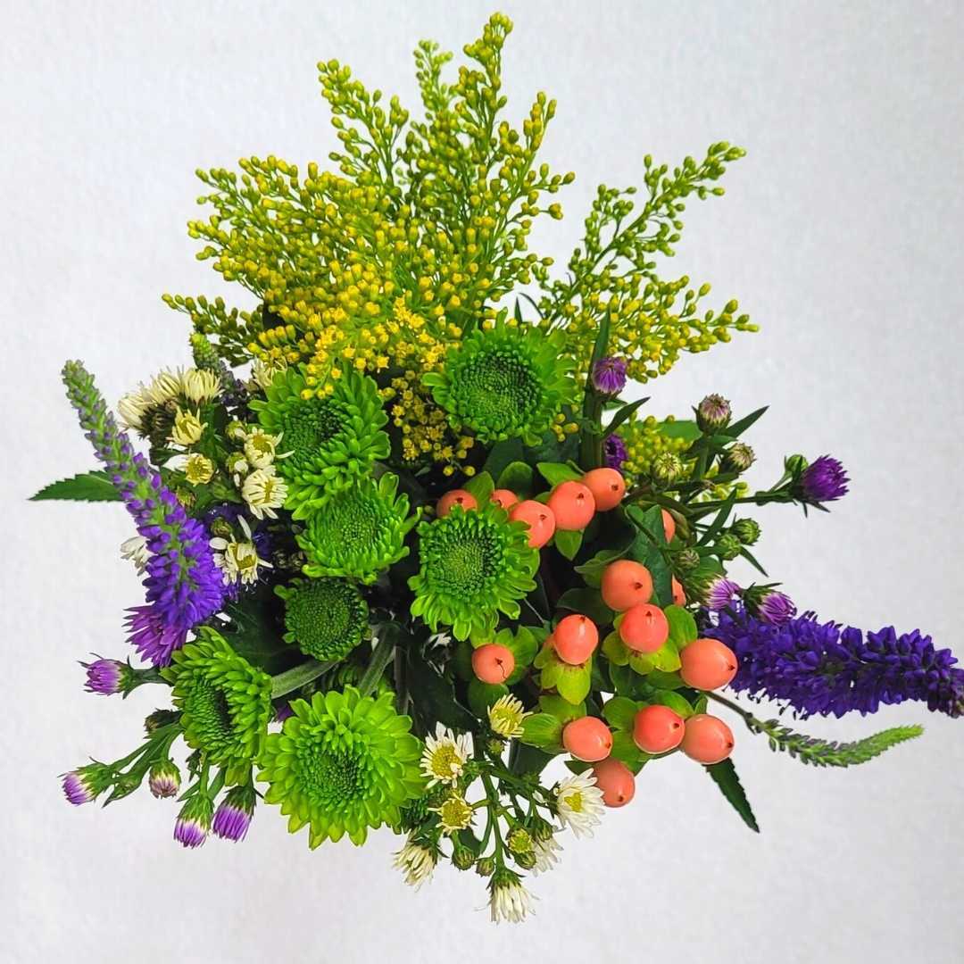 un ramo de flores con flores verdes, amarillas y moradas