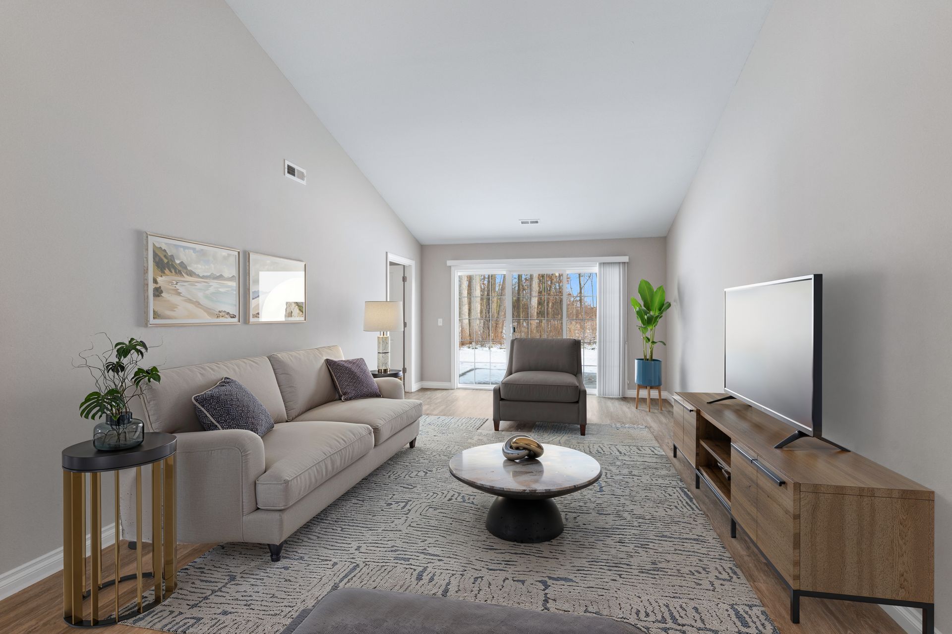 Living room with couch, chair, coffee table, TV, rug, and sliding glass doors to a snowy outdoor view.
