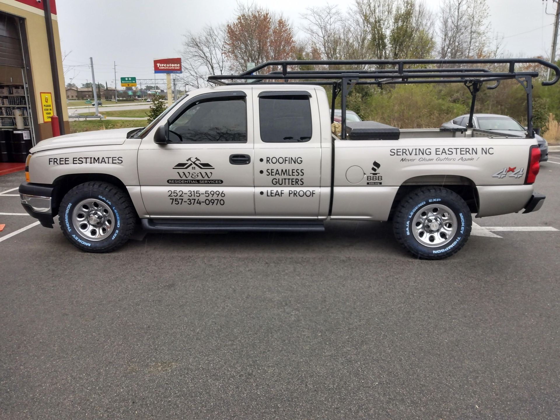 A silver pickup truck is parked in a parking lot.