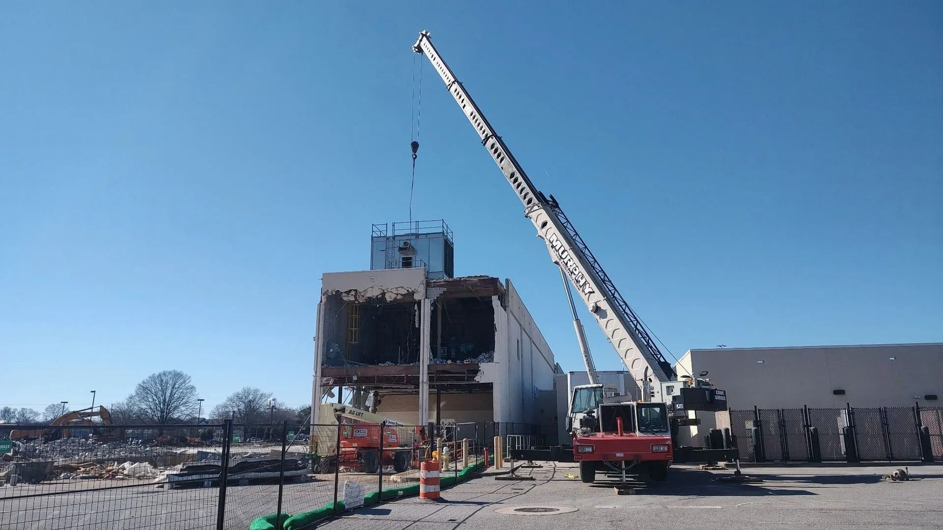 A large crane dismantling a building on a construction site.