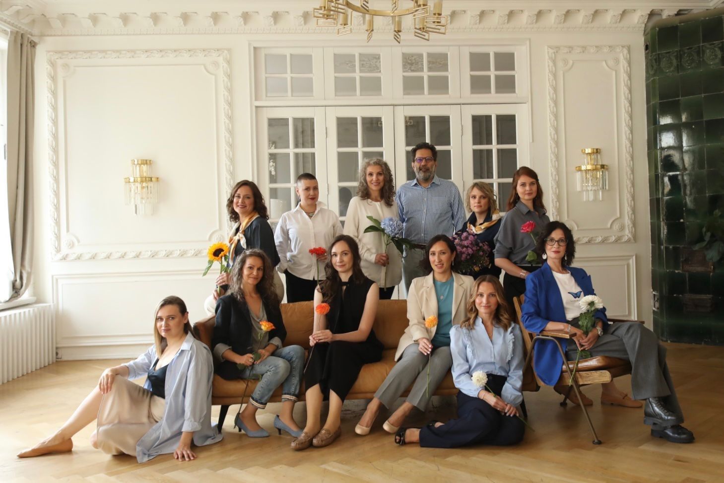 A group of people are posing for a picture while sitting on a couch.