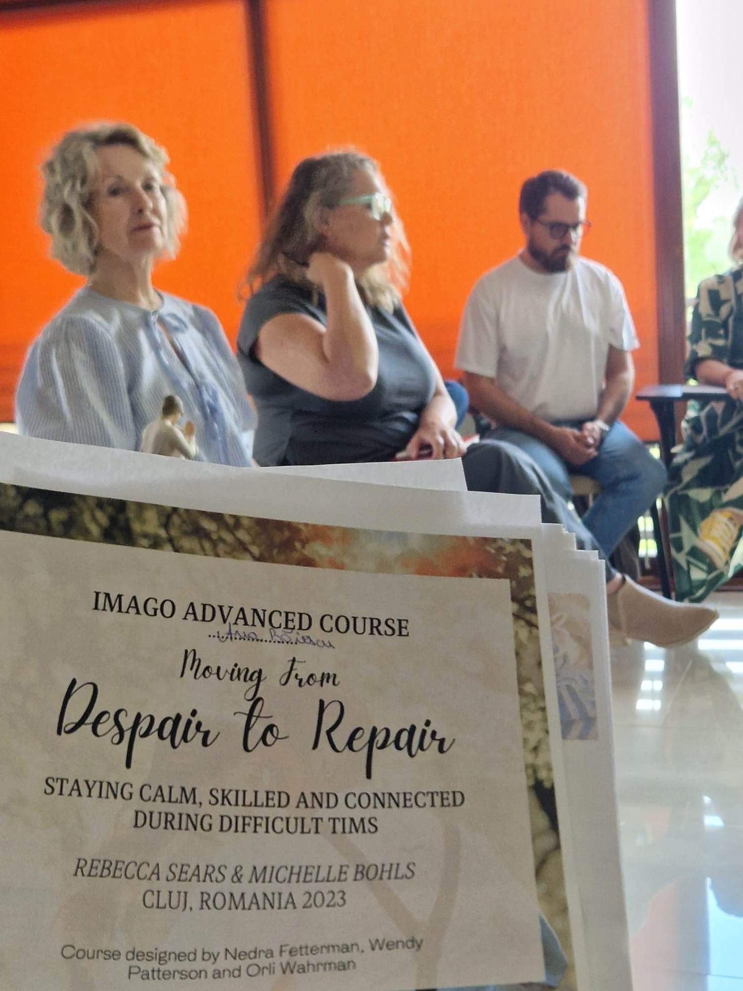 A group of people are sitting in front of a sign that says despair to repair