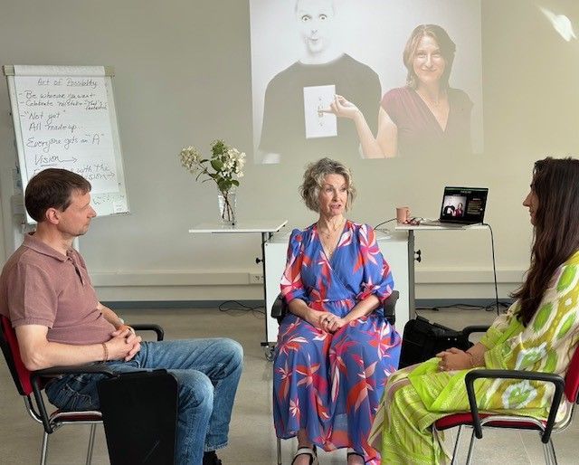 A group of people are sitting in chairs in front of a projector screen