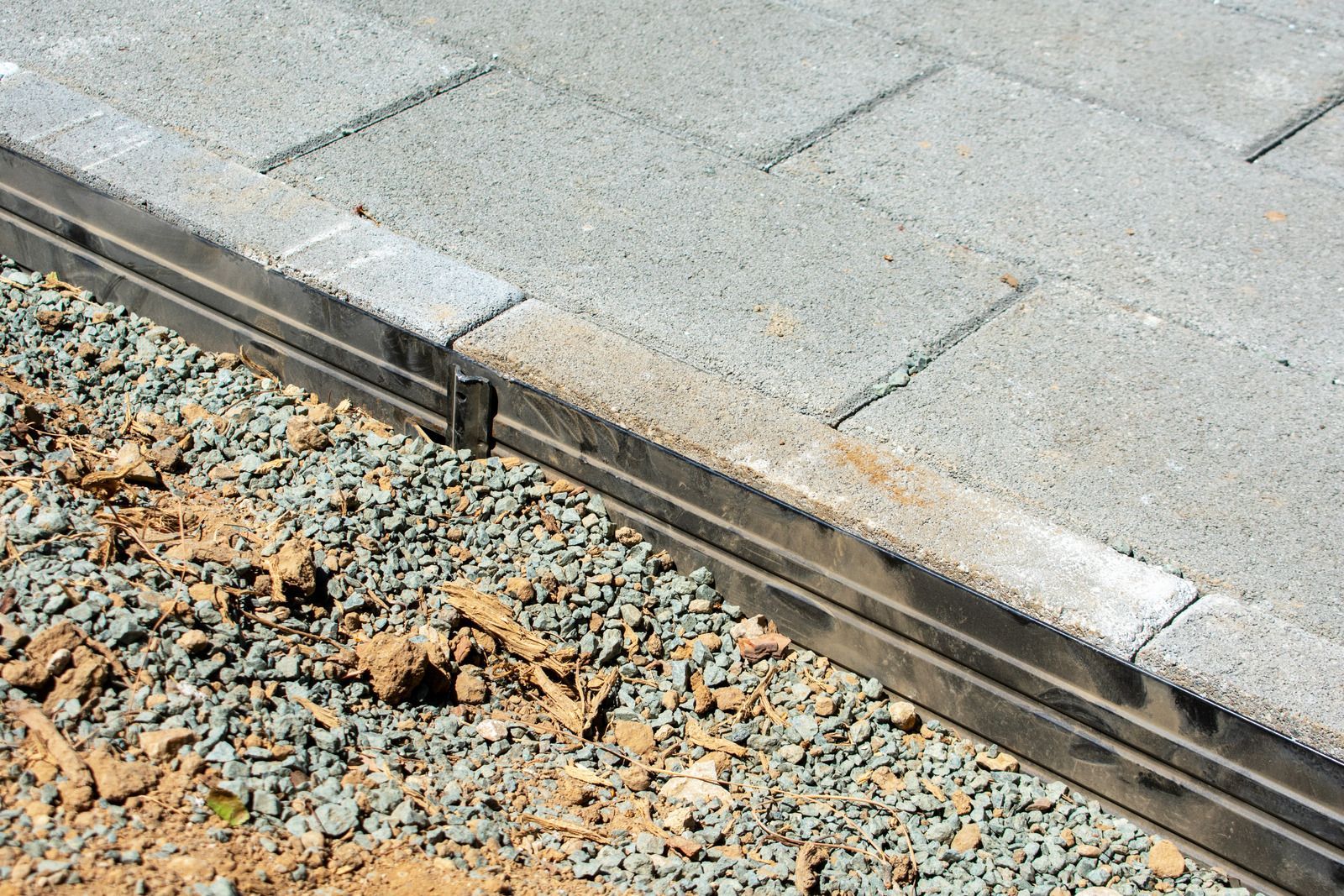 Pile of stones with burning flowers on top, set against green grass and hill.