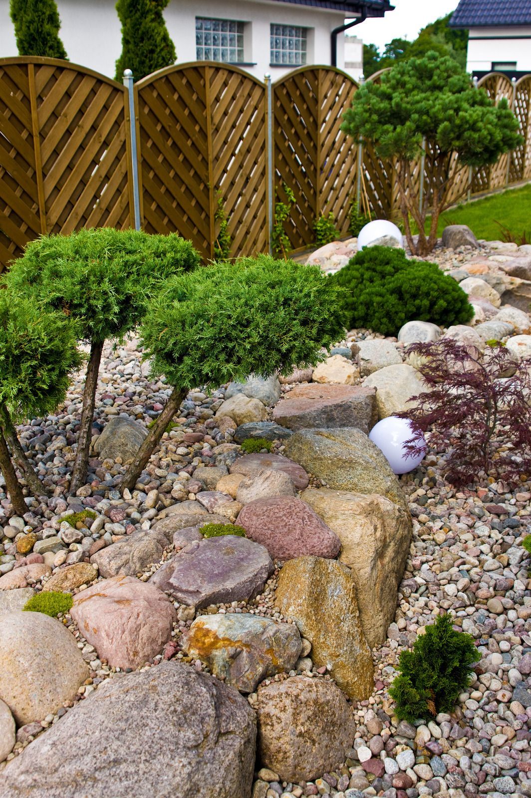 Close-up of a pile of various sized smooth, brown and gray river rocks.