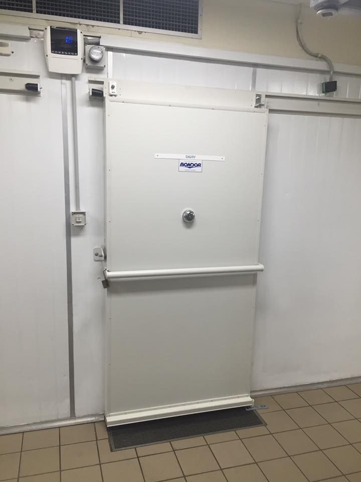 A White Door is Open in a Room With a Tiled Floor — Todd Hayes Refrigeration & Air Conditioning Pty Ltd in Casino, NSW