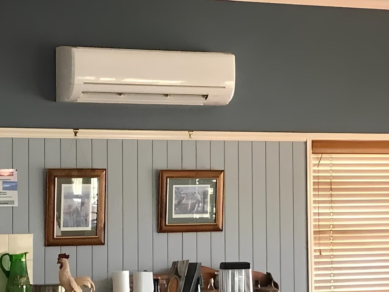 A White Air Conditioner is Hanging From the Ceiling in a Kitchen — Todd Hayes Refrigeration & Air Conditioning Pty Ltd in Kyogle, NSW