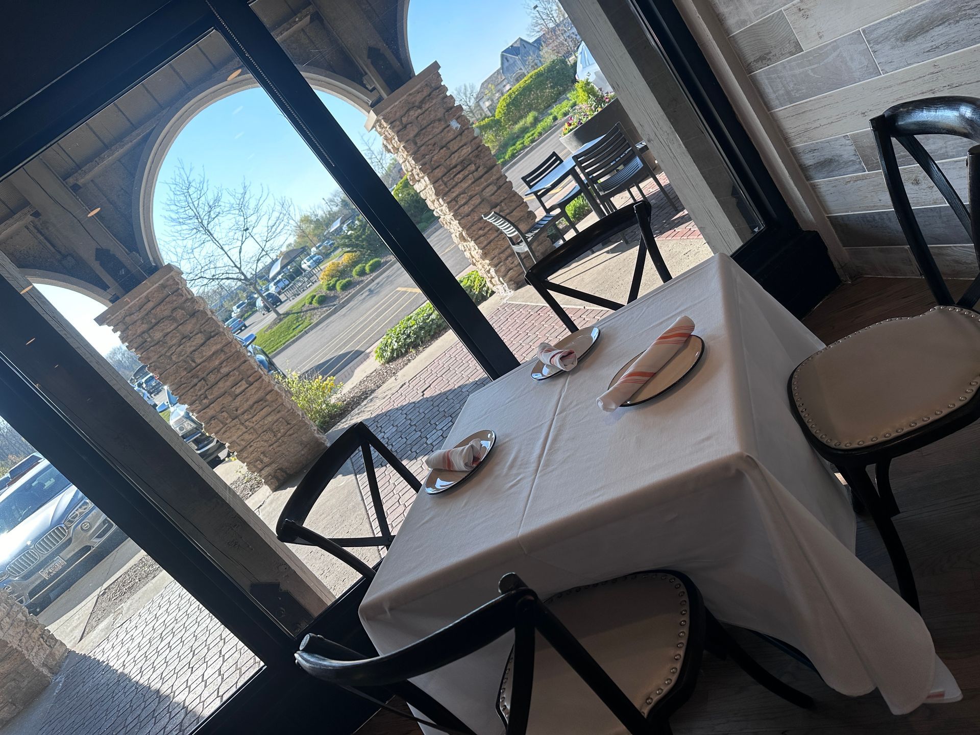 A restaurant table with a white table cloth and black chairs