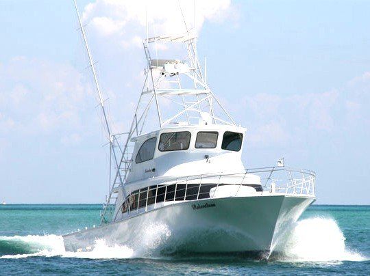 Fishing Destin, FL | Destin Harbor | Charter Boat Relentless | www.charterboatrelentless.com | A Luxury Charter Boat at Everyday Rates | 65' x 20' | A large white boat, Charter Boat Relentless, is floating on top of a body of water.
