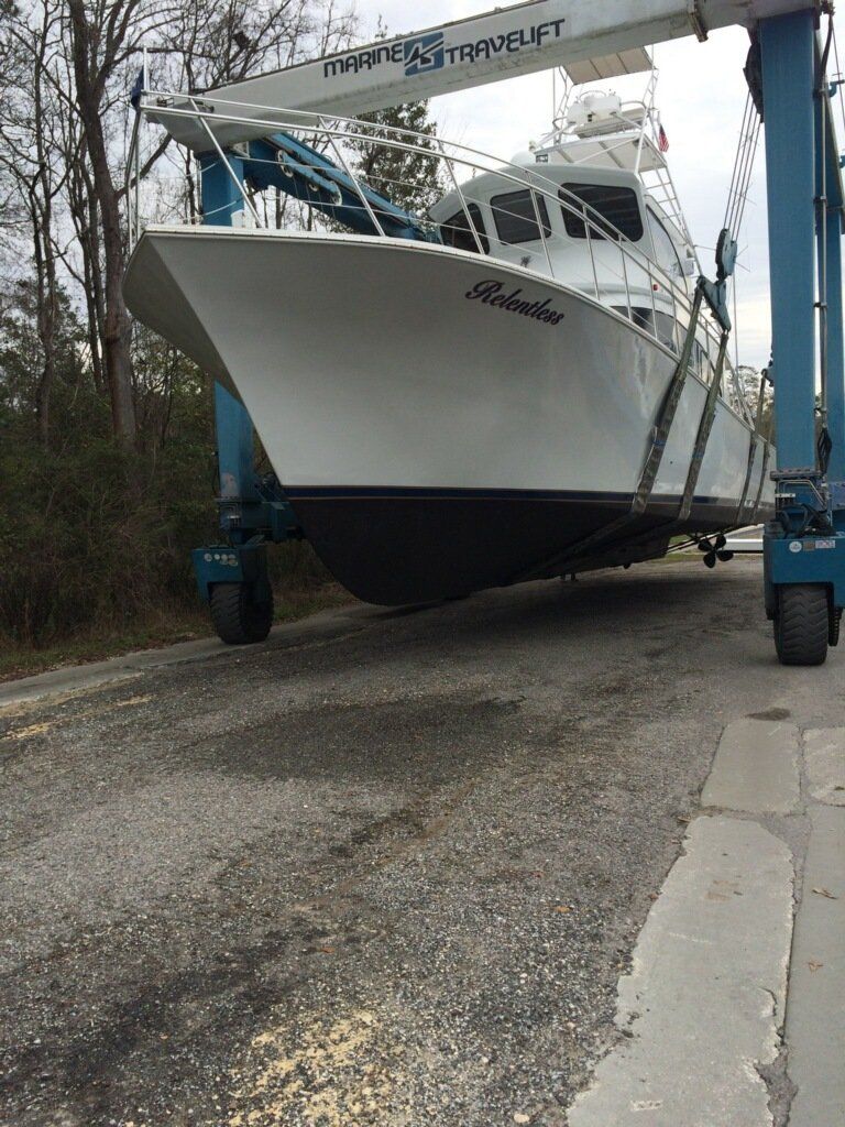 A large white boat is being lifted by a crane.