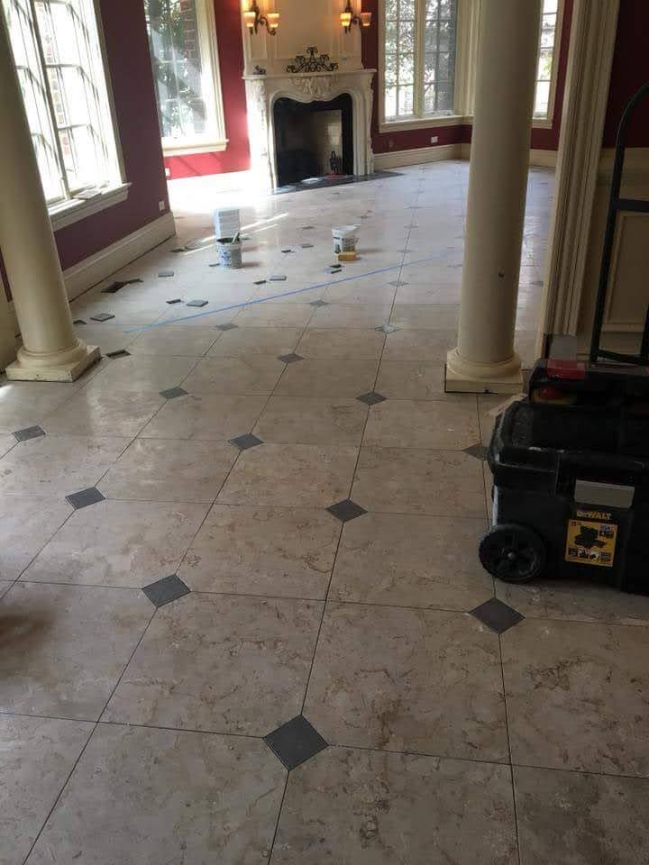 Damaged marble-floored room with scattered debris, columns, a fireplace, and a generator cart.