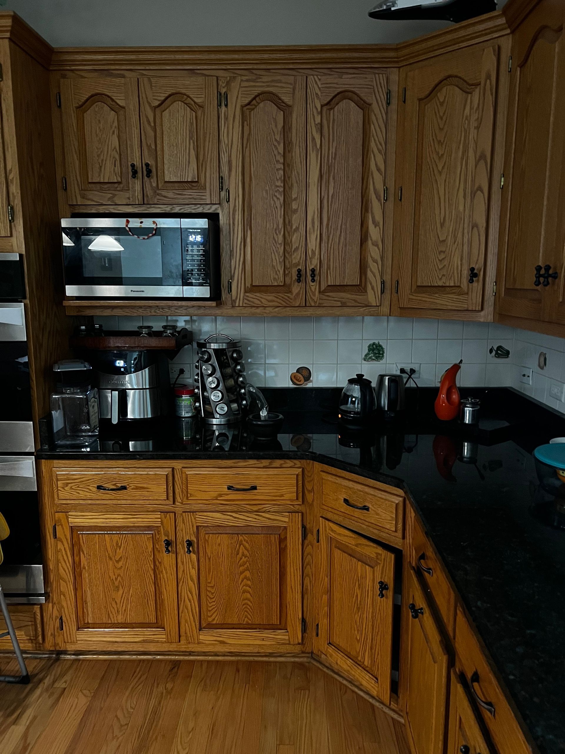 Wooden kitchen cabinets with black countertops and a coffee maker on the counter