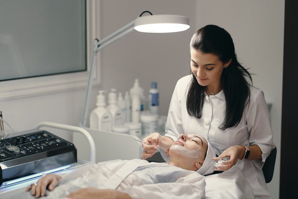 A woman is getting a facial treatment at a beauty salon.