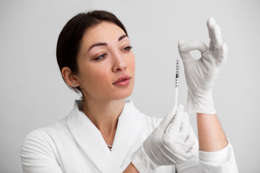 A female doctor is holding a syringe in her hand.