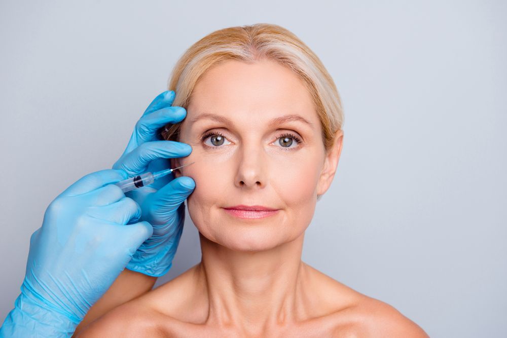 A woman is getting a botox injection in her face.