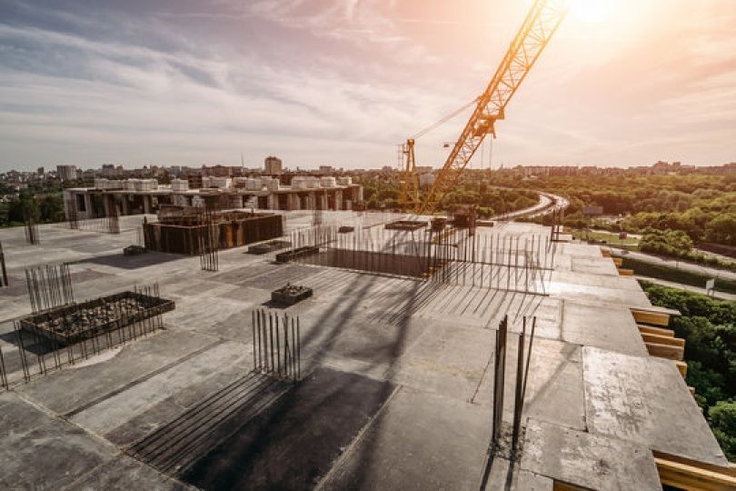 Un grand bâtiment est en construction avec une grue en arrière-plan.