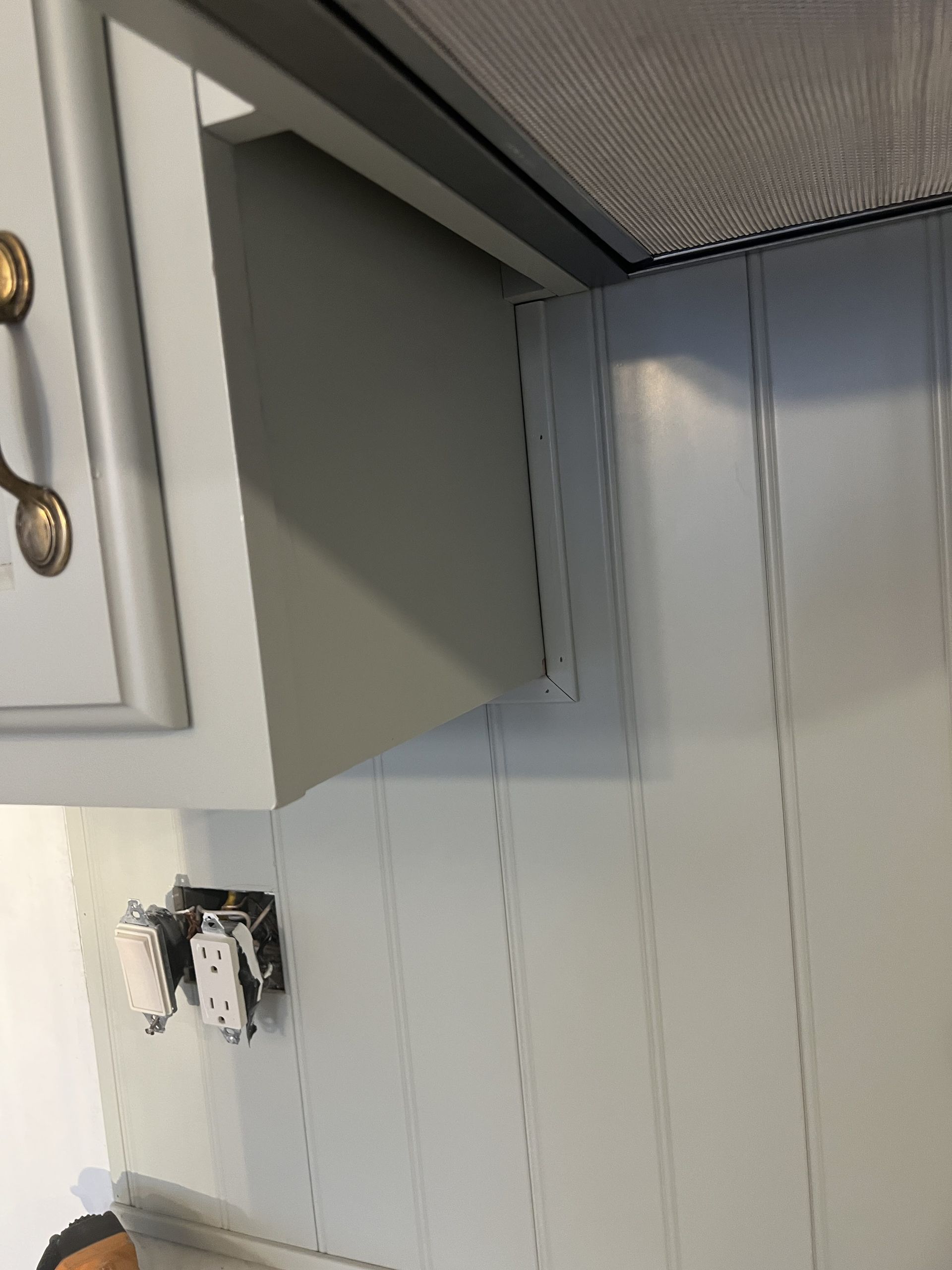 Kitchen cabinet and backsplash with electrical outlets.