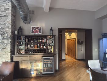 Hand painting a white wall with a blue paint roller.