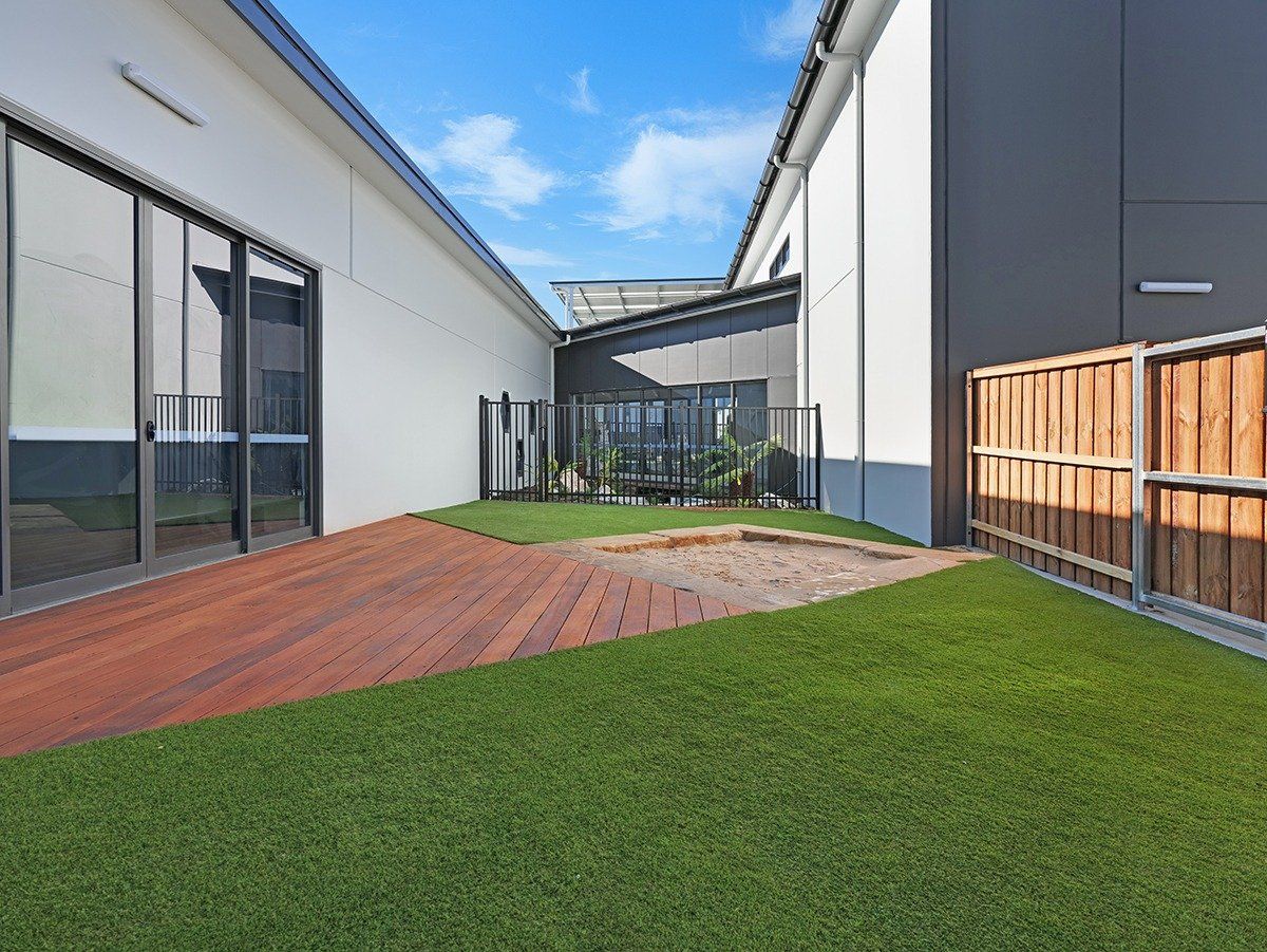 There is a wooden deck in the middle of the yard.