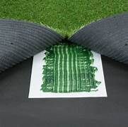 A piece of artificial grass is sitting on top of a piece of paper.