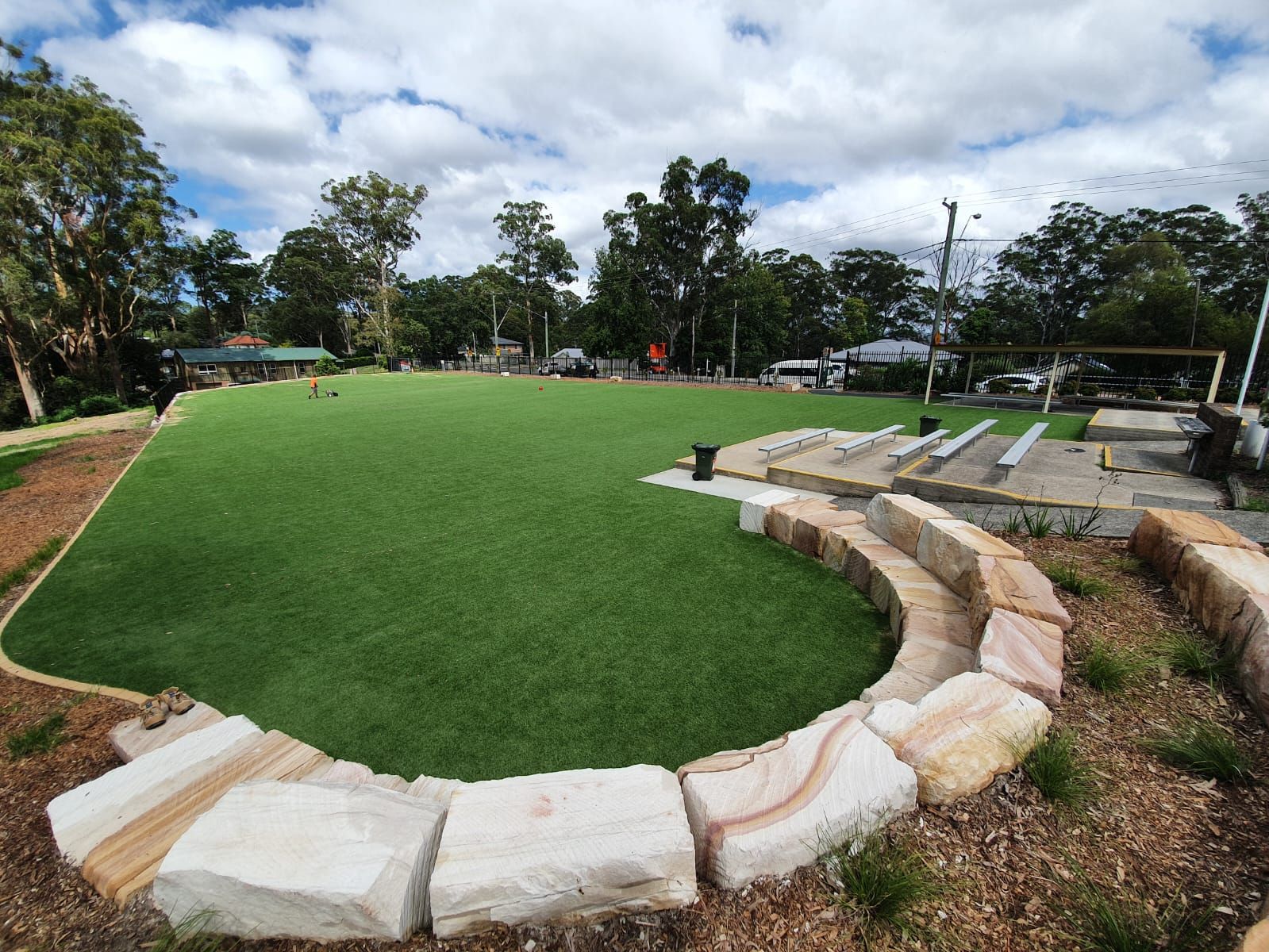 A large grassy field with rocks in the middle of it