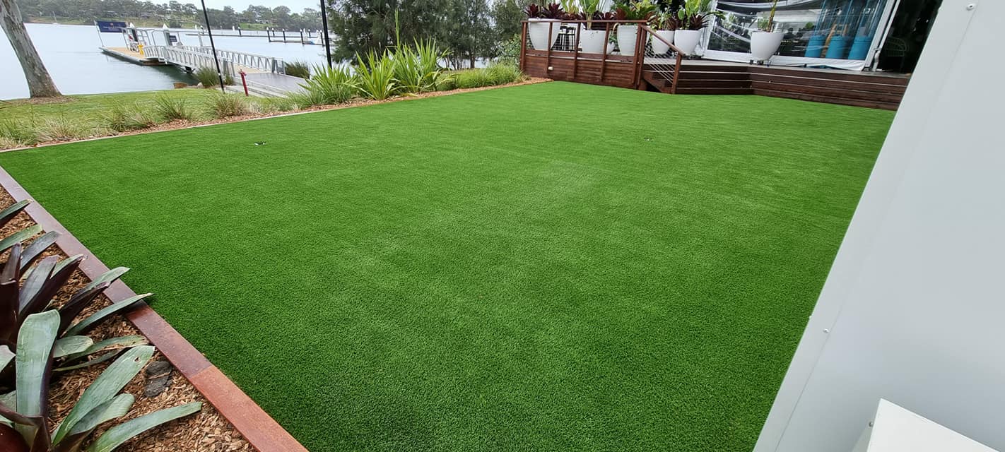 A large lawn with a view of a body of water in the background.