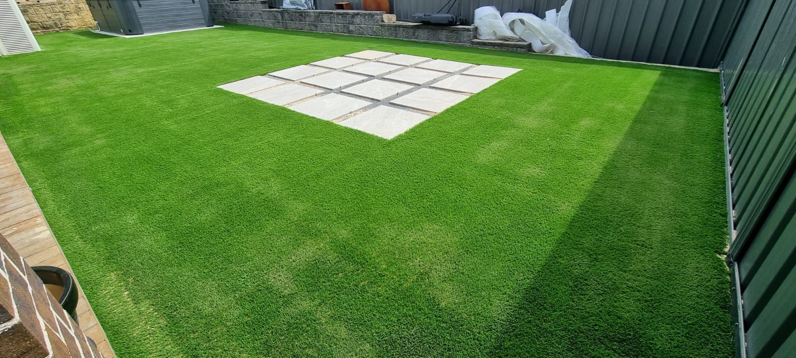 There is a square in the middle of the grass in the backyard.