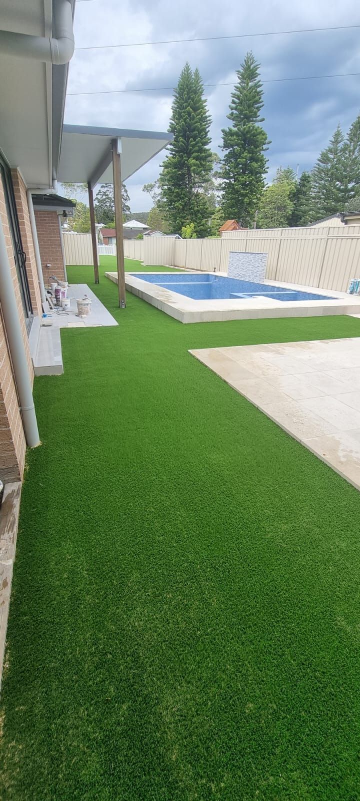 There is a swimming pool in the backyard of a house.