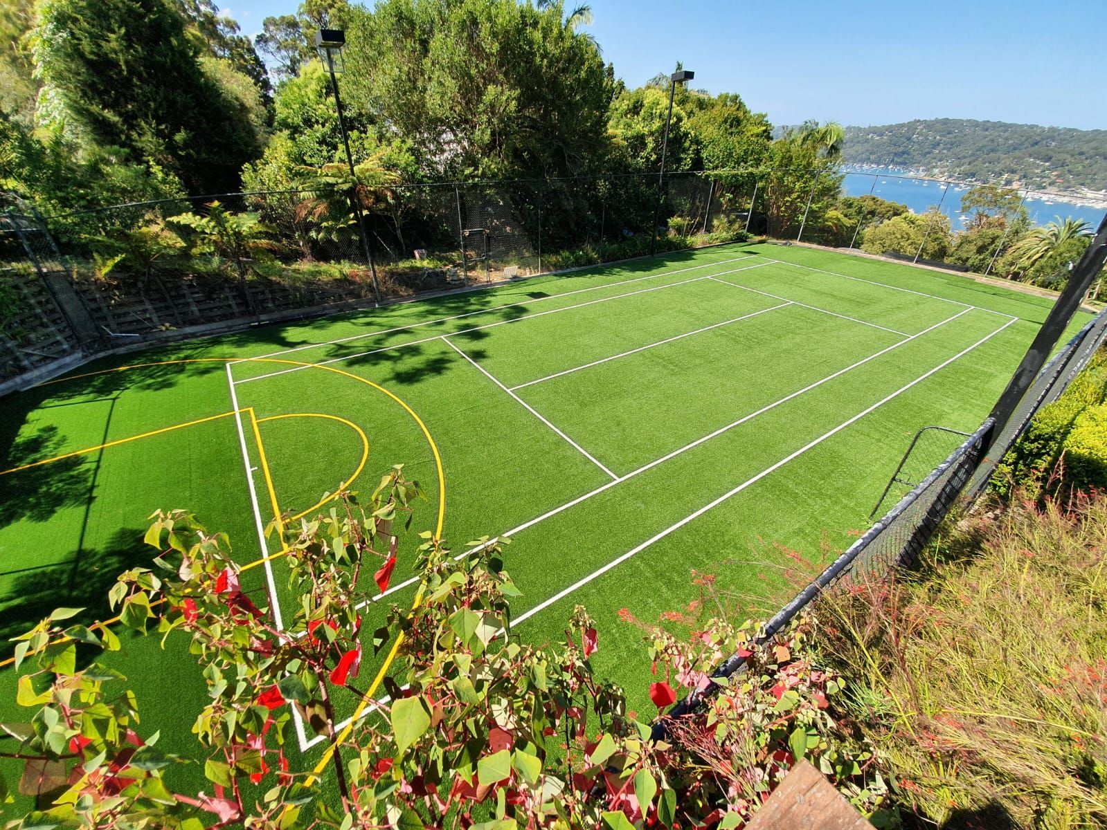 An aerial view of a soccer field surrounded by trees and a body of water.