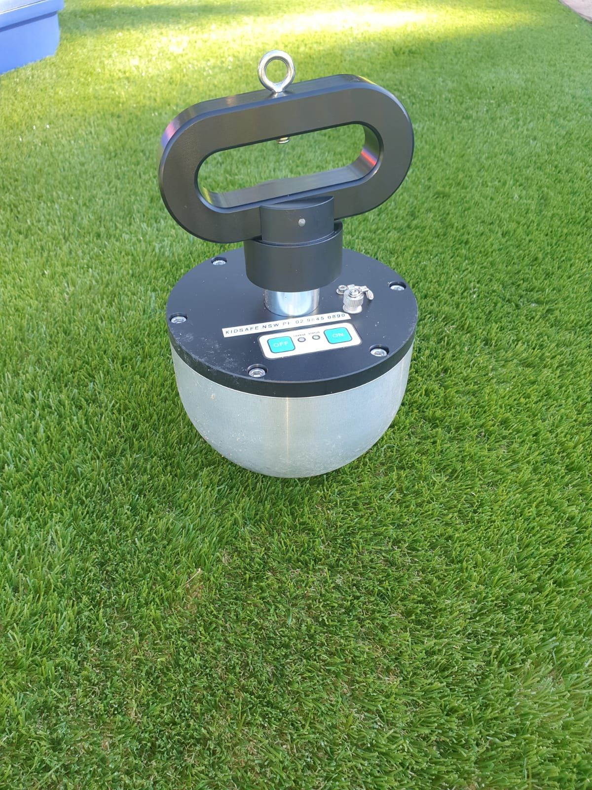 A lantern is sitting on top of a lush green field.