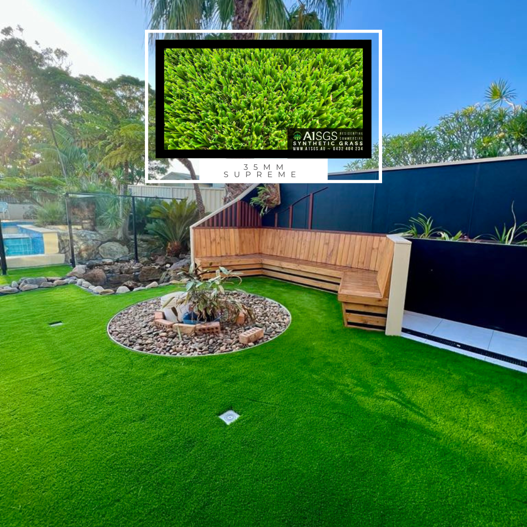 A lush green lawn with a wooden bench in the middle of it.