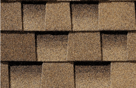 Brown asphalt roof shingles in a close-up view.