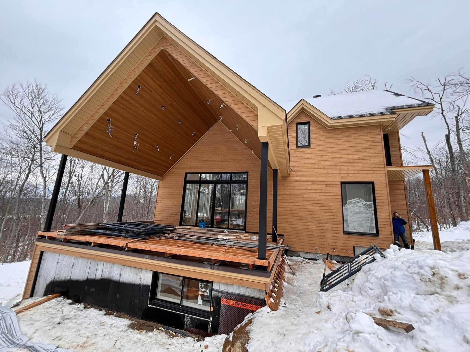 Un parasol de plage à rayures jaunes et blanches éclatantes se dresse sur une plage de sable fin sous un ciel bleu limpide.